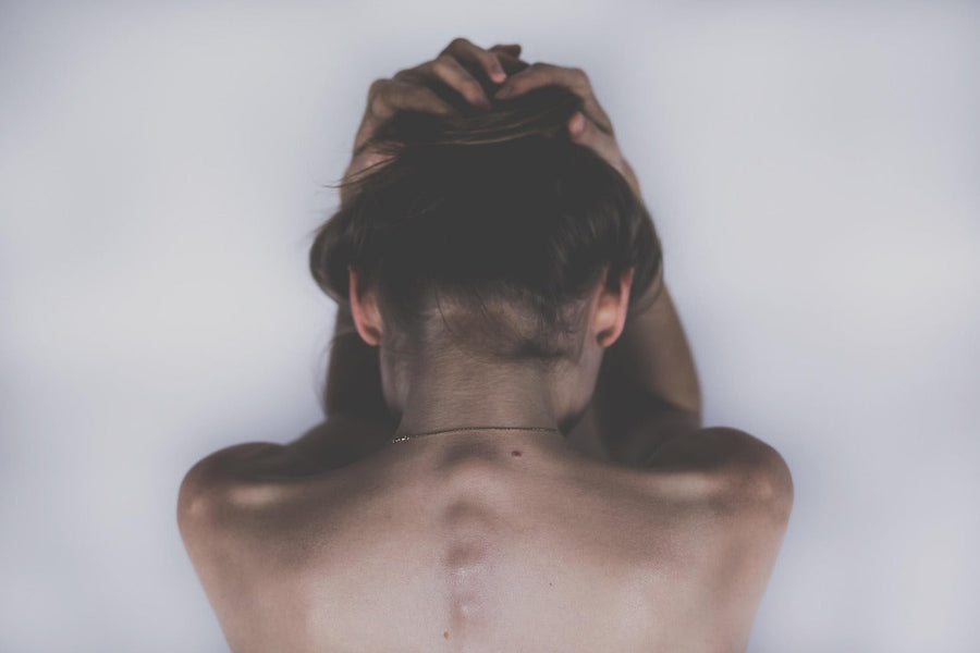 Vrouw met de handen in haar nek die pijn heeft